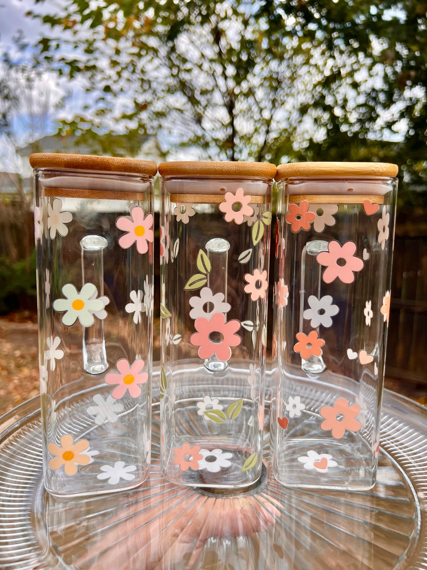 Taza de vidrio con daisies de colores