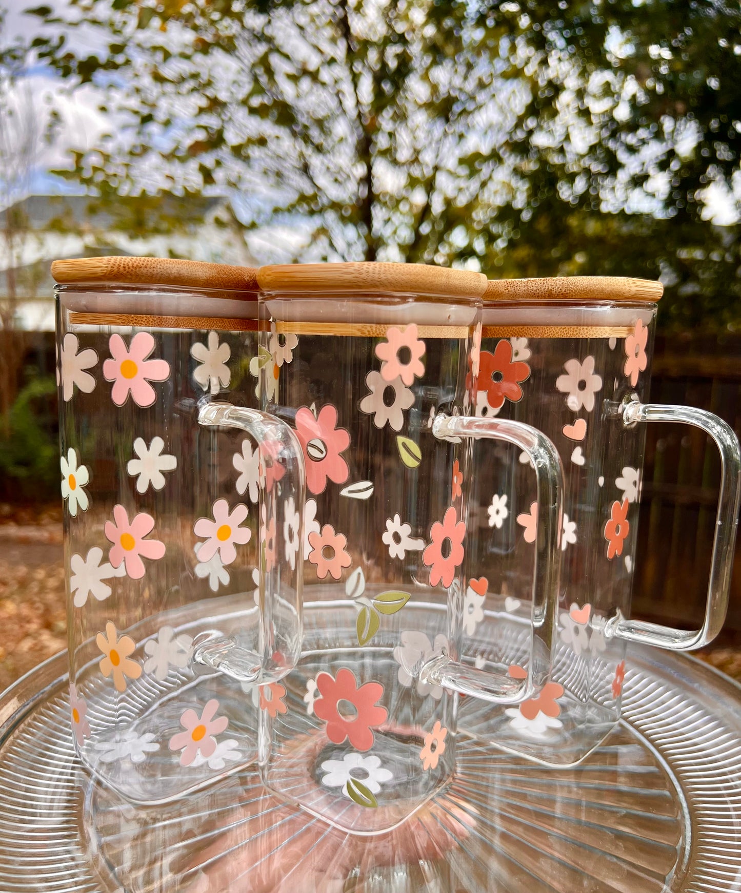 Taza de vidrio con daisies de colores