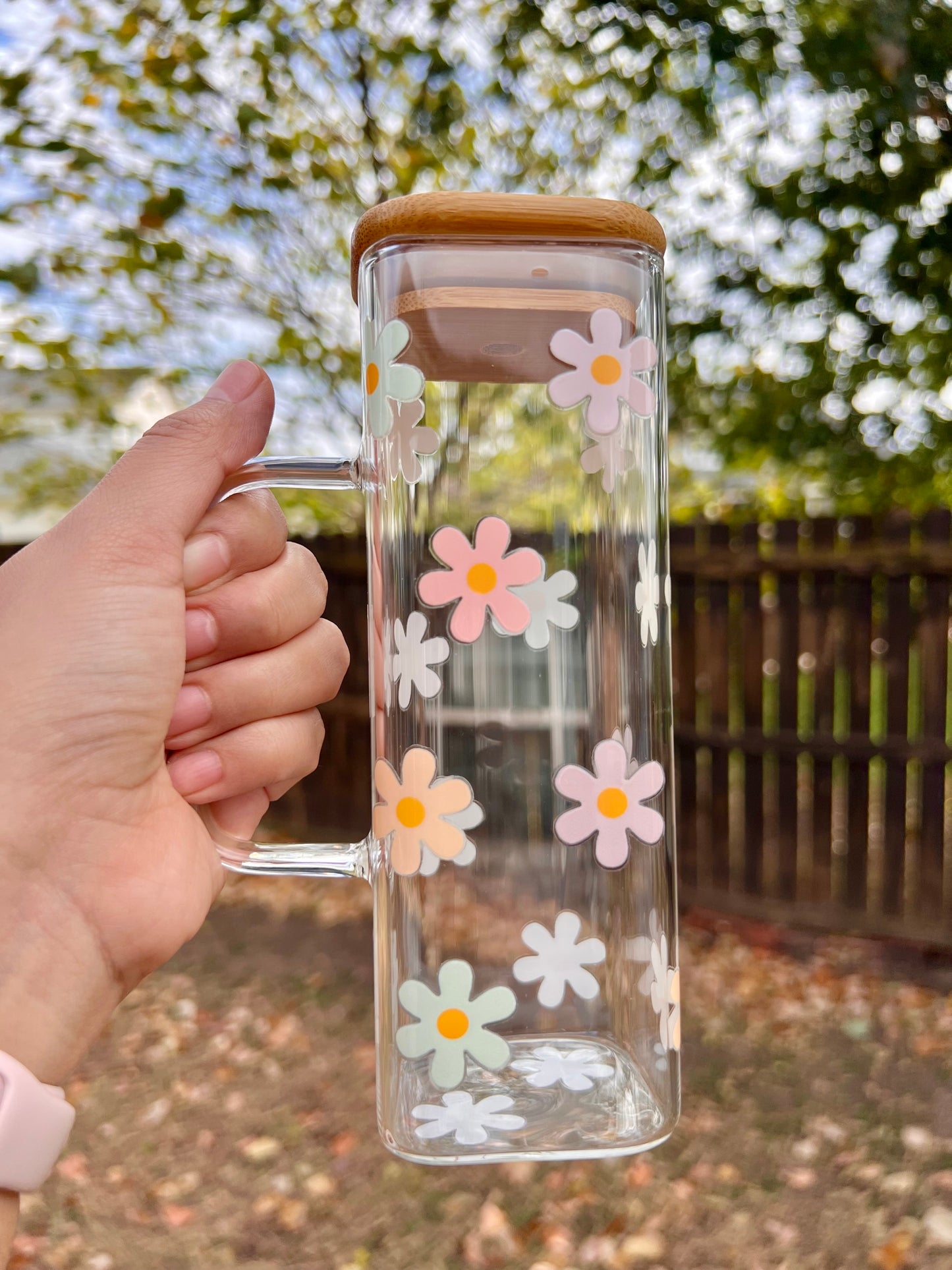 Taza de vidrio con daisies de colores