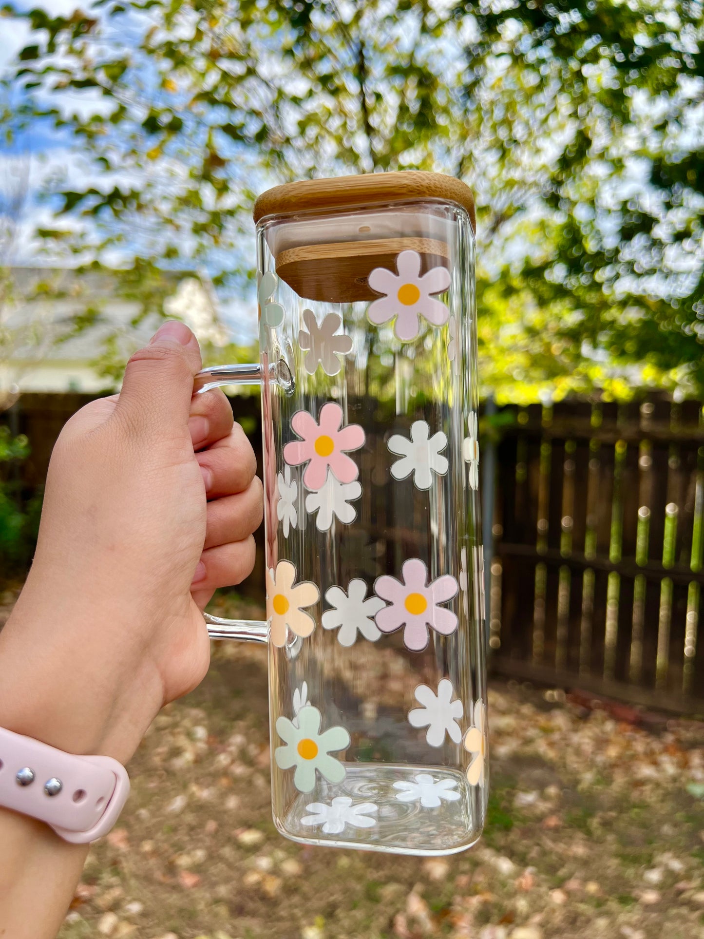 Taza de vidrio con daisies de colores