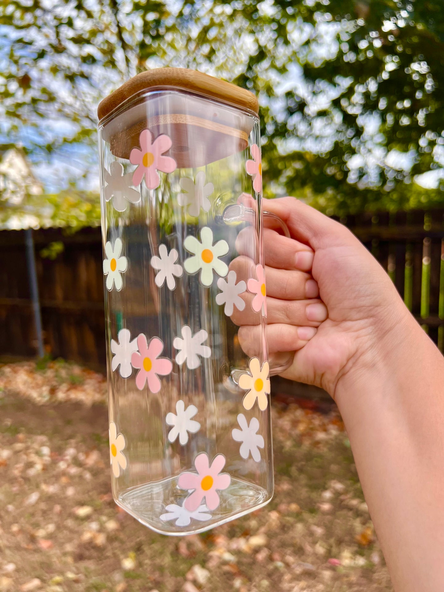 Taza de vidrio con daisies de colores