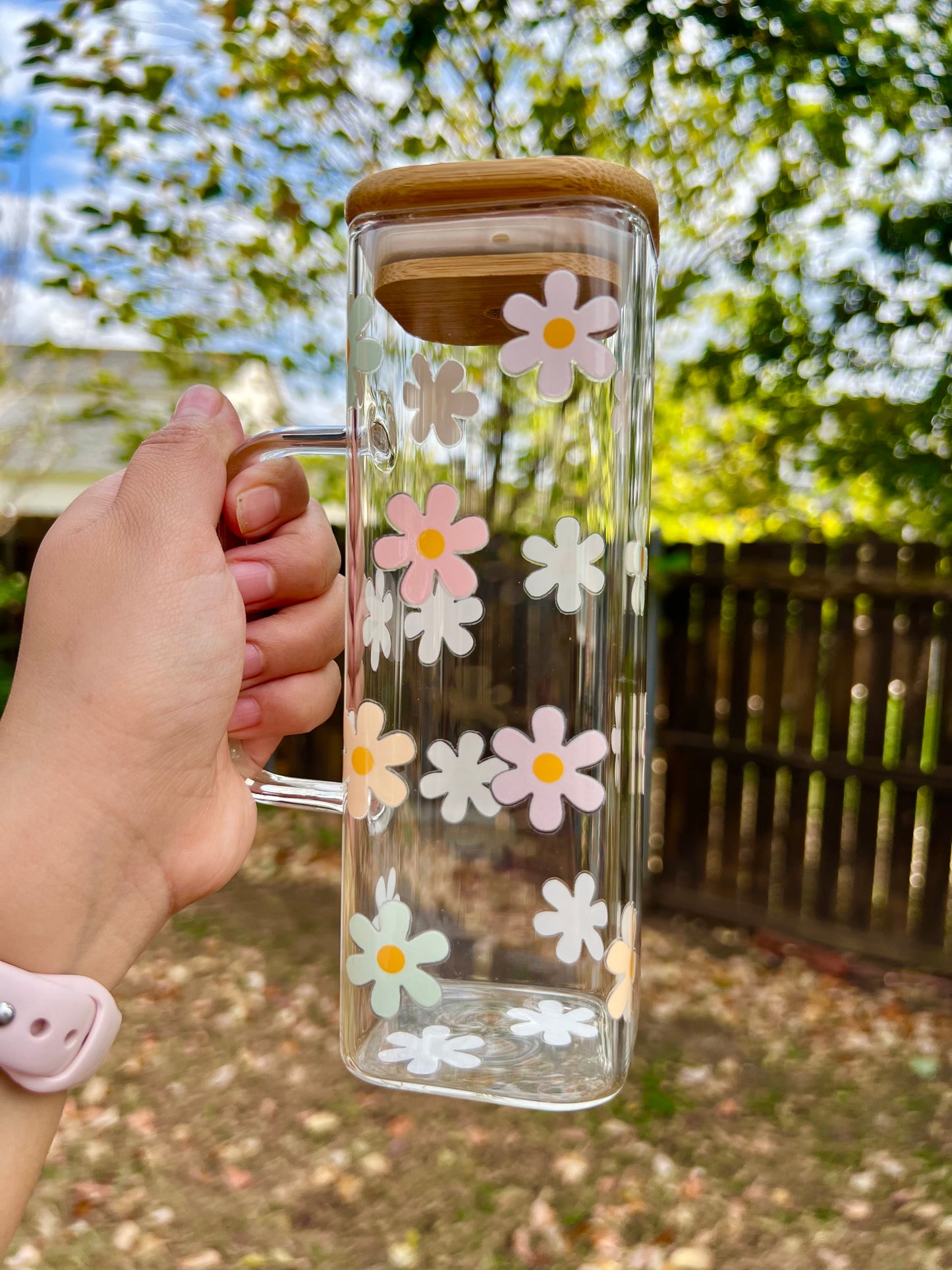 Taza de vidrio con daisies de colores